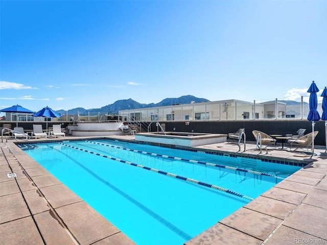 view of swimming pool featuring a mountain view, a community hot tub, and a patio