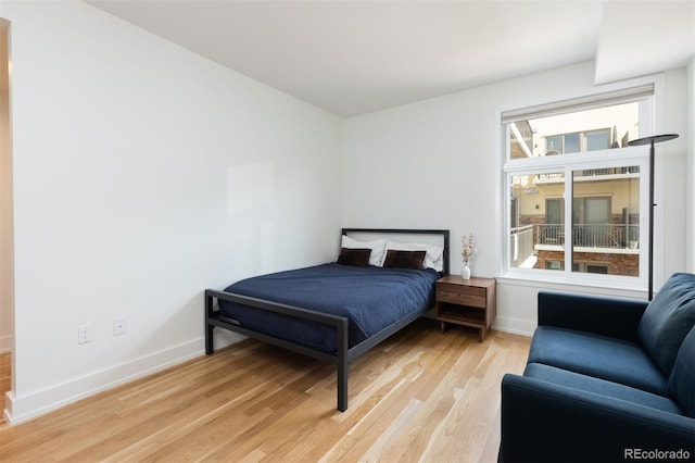 bedroom featuring multiple windows and light hardwood / wood-style flooring