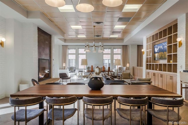 dining room with a drop ceiling and a fireplace