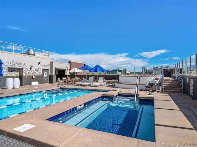 view of swimming pool featuring a community hot tub and a patio