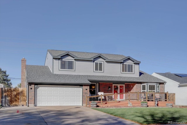 view of front of house featuring a deck, a front yard, and a garage