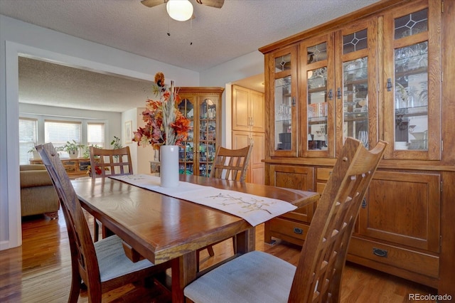 dining area featuring a textured ceiling, light hardwood / wood-style floors, and ceiling fan