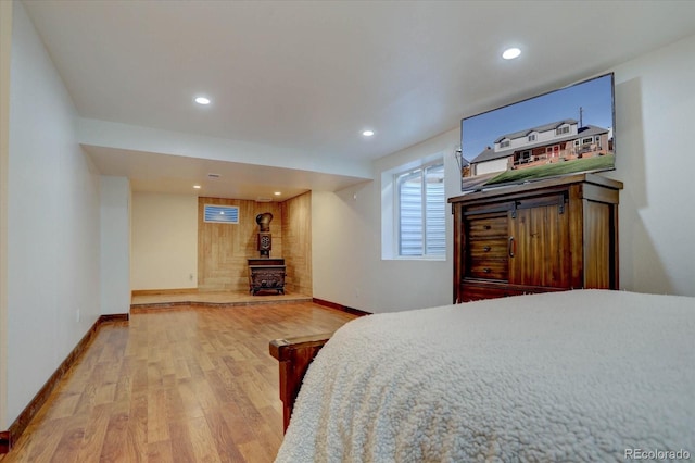 bedroom with wood-type flooring and a wood stove