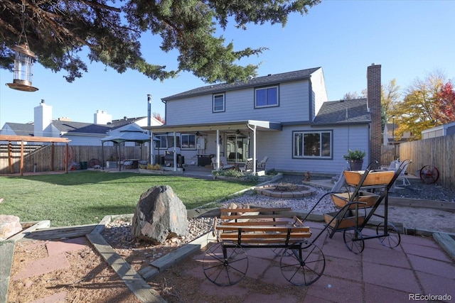 rear view of house with a gazebo, an outdoor fire pit, a patio, and a lawn