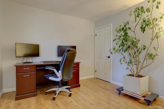 home office with light hardwood / wood-style flooring