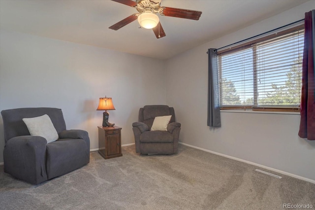 living area featuring carpet flooring and ceiling fan