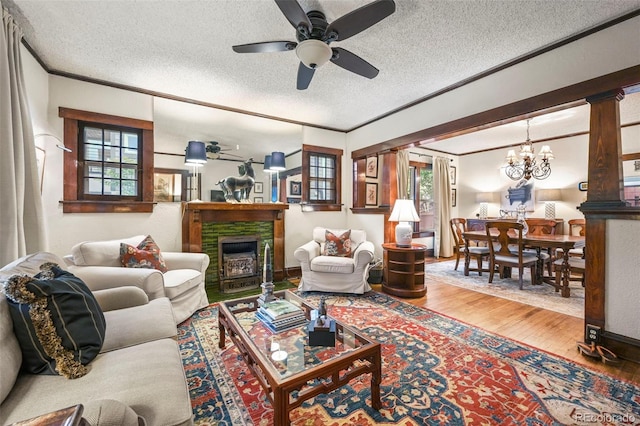 2131 Eliot St, Denver, CO 80211 - living area featuring a textured ceiling, ceiling fan, a fireplace, a chandelier, and ornamental molding
