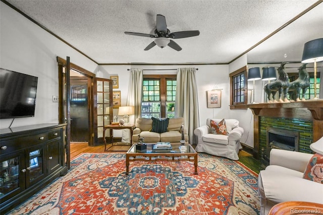 2131 Eliot St, Denver, CO 80211 - living room with wood finished floors, ornamental molding, a ceiling fan, a textured ceiling, and a fireplace with flush hearth