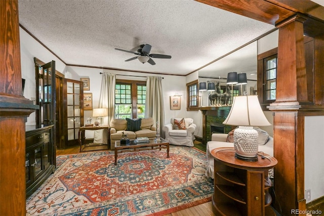 2131 Eliot St, Denver, CO 80211 - living area with ceiling fan, ornamental molding, wood finished floors, a fireplace, and a textured ceiling