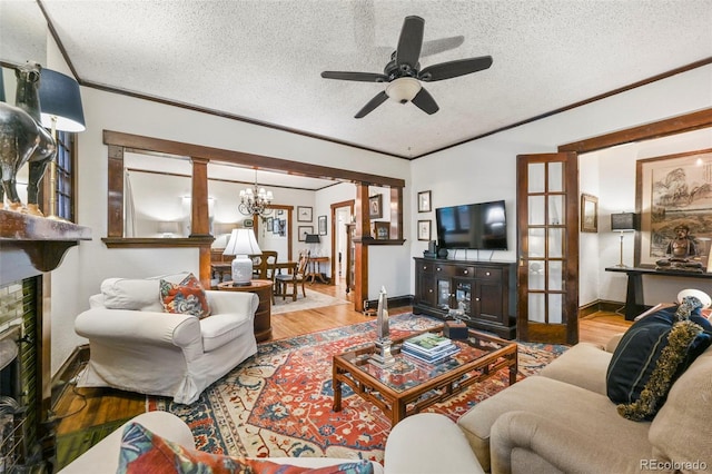 2131 Eliot St, Denver, CO 80211 - living area with a textured ceiling, ceiling fan, ornamental molding, wood finished floors, and a chandelier