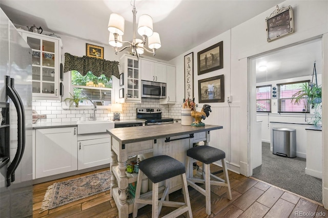 2131 Eliot St, Denver, CO 80211 - kitchen featuring appliances with stainless steel finishes, a sink, dark wood-type flooring, and tasteful backsplash