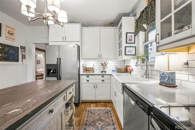 2131 Eliot St, Denver, CO 80211 - kitchen with appliances with stainless steel finishes, a sink, wood finished floors, decorative light fixtures, and a chandelier