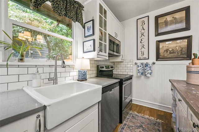 2131 Eliot St, Denver, CO 80211 - kitchen with stainless steel appliances, a sink, dark wood-style flooring, tasteful backsplash, and glass insert cabinets