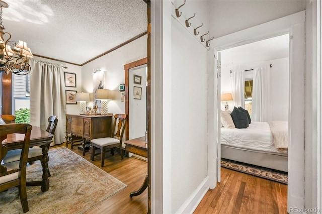 2131 Eliot St, Denver, CO 80211 - corridor with wood finished floors, a textured ceiling, a chandelier, and ornamental molding