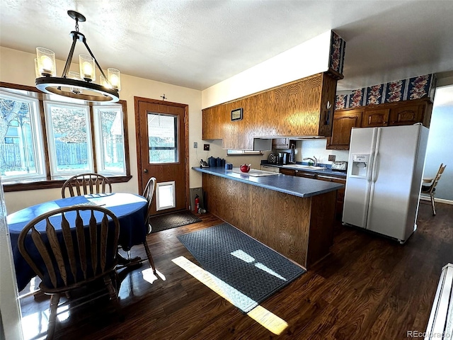 kitchen with sink, an inviting chandelier, hanging light fixtures, dark hardwood / wood-style flooring, and white refrigerator with ice dispenser