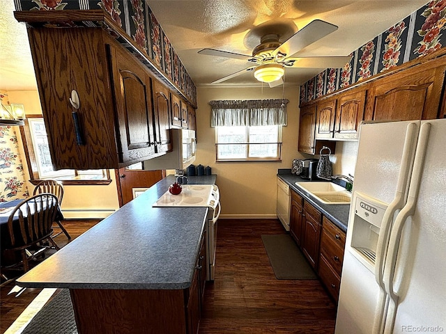 kitchen featuring white appliances, a baseboard radiator, dark hardwood / wood-style flooring, ceiling fan, and sink