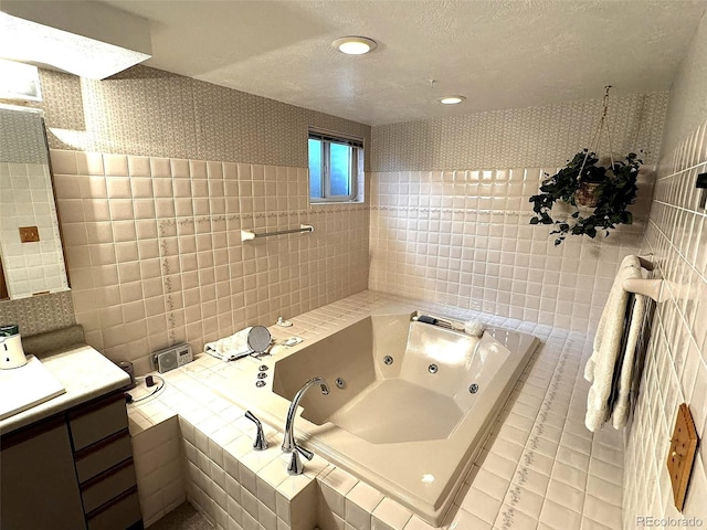 bathroom featuring a textured ceiling, tile patterned flooring, tile walls, vanity, and a relaxing tiled tub