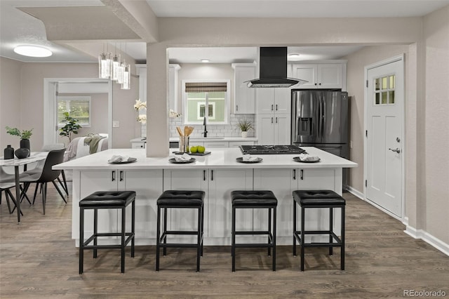 1120 S Harrison St, Denver, CO 80210 - kitchen featuring extractor fan, appliances with stainless steel finishes, a breakfast bar, and white cabinetry