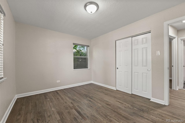 1120 S Harrison St, Denver, CO 80210 - unfurnished bedroom with dark wood-style flooring, a closet, and a textured ceiling