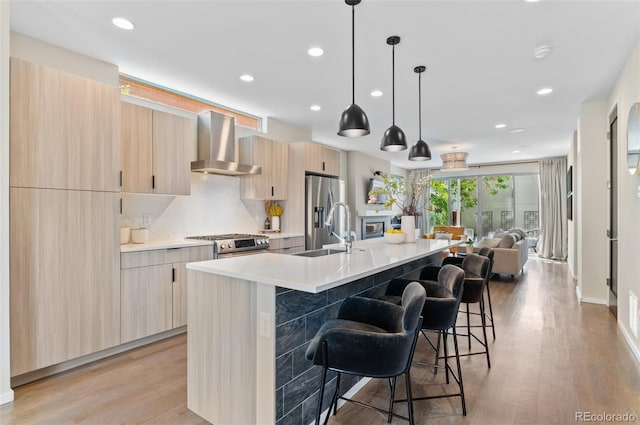 3885 Vrain St, Denver, CO 80212 - kitchen with wall chimney range hood, a sink, appliances with stainless steel finishes, modern cabinets, and light countertops