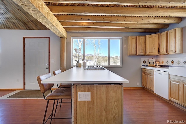 kitchen featuring light wood-style flooring, a breakfast bar, dishwasher, and beamed ceiling