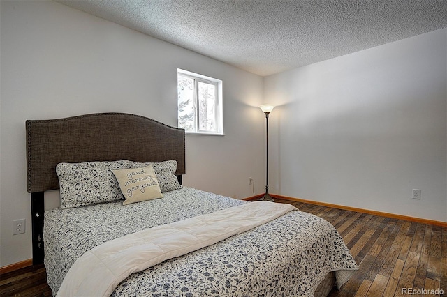 bedroom featuring a textured ceiling, hardwood / wood-style floors, and baseboards