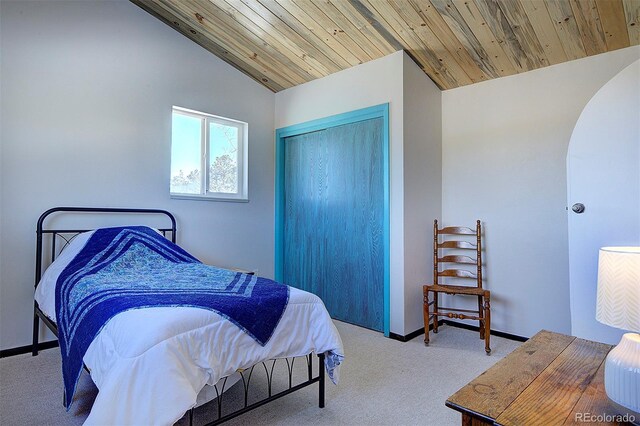 bedroom with carpet floors, wooden ceiling, vaulted ceiling, and a closet