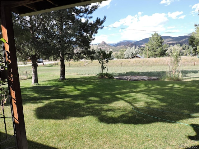 view of yard with a mountain view and a rural view