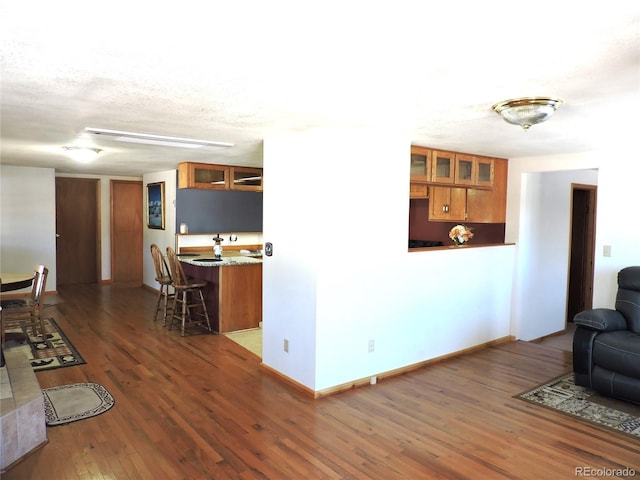 living room with a textured ceiling and dark hardwood / wood-style flooring