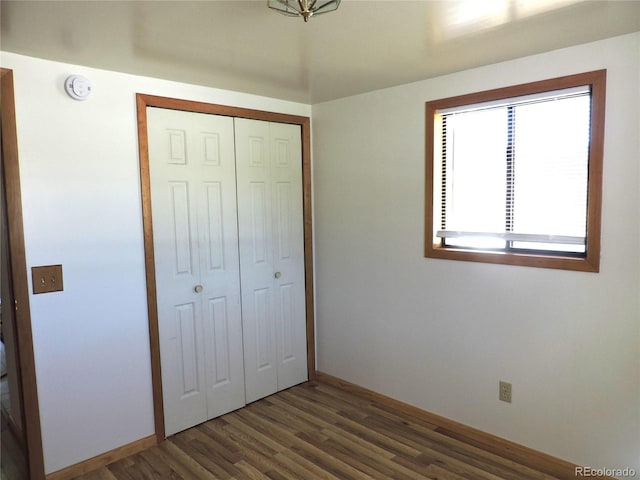 unfurnished bedroom with a closet and dark hardwood / wood-style floors