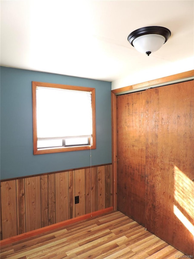 spare room with wooden walls and light hardwood / wood-style floors