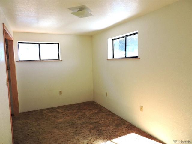 spare room featuring dark carpet