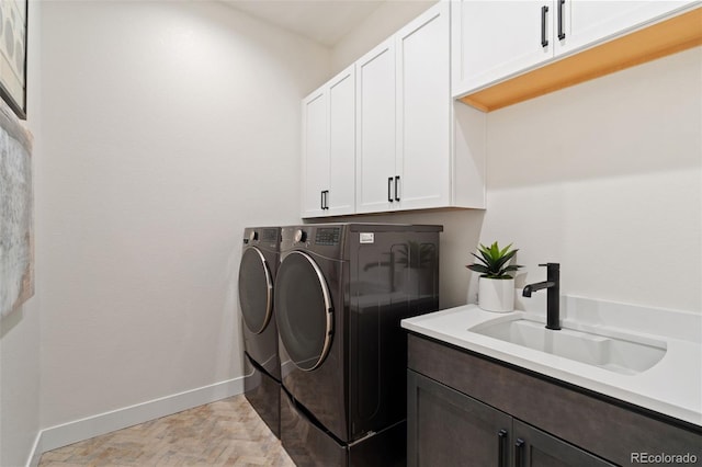 laundry room with cabinets, independent washer and dryer, and sink