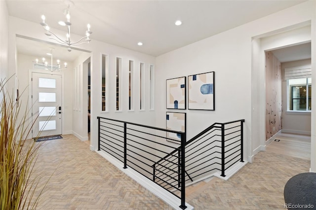 foyer entrance featuring light parquet flooring and an inviting chandelier