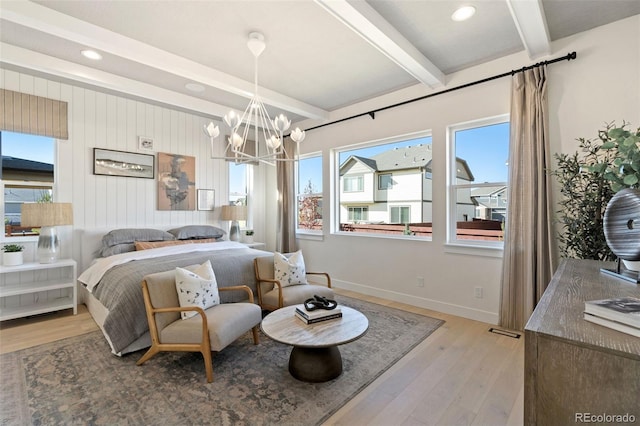 bedroom with an inviting chandelier, beam ceiling, and light hardwood / wood-style flooring