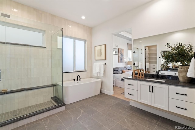 bathroom with vanity and shower with separate bathtub