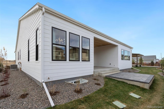 view of property exterior with a yard, central AC, and a patio area