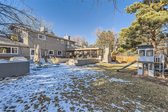 yard covered in snow with a fire pit and a playground