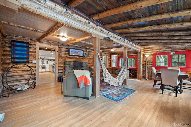 5732 Santa Clara Rd, Indian Hills, CO 80454 - living area featuring log walls, hardwood / wood-style flooring, a wood ceiling with exposed beams, and a fireplace