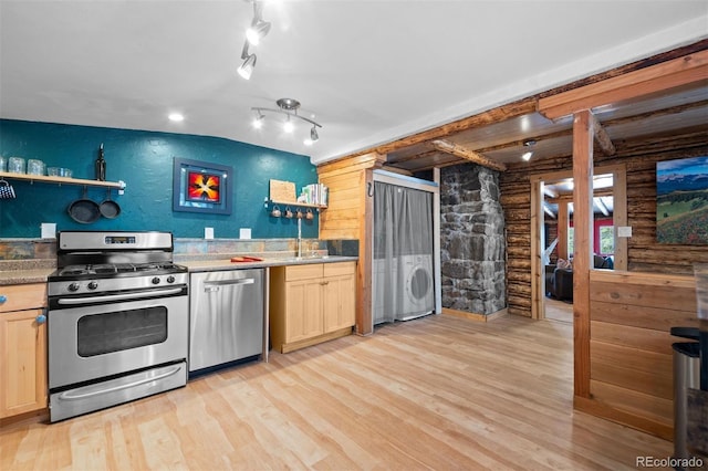 5732 Santa Clara Rd, Indian Hills, CO 80454 - kitchen with appliances with stainless steel finishes, washer / dryer, light wood-style floors, light brown cabinets, and log walls