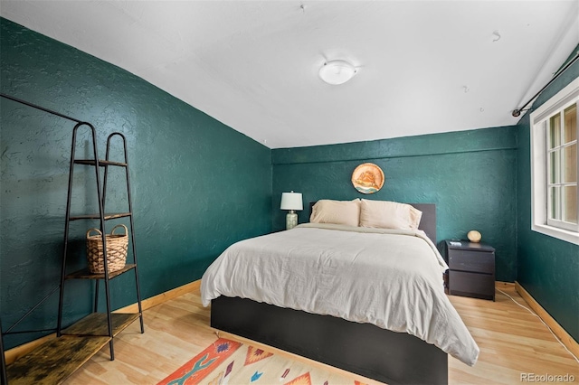 5732 Santa Clara Rd, Indian Hills, CO 80454 - bedroom with wood finished floors, vaulted ceiling, and a textured wall