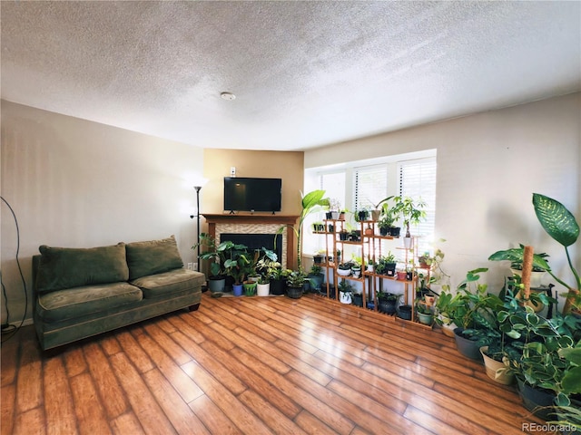 1120 S Waco St Unit A, Aurora, CO 80017 - living room with a textured ceiling, hardwood / wood-style flooring, and a fireplace