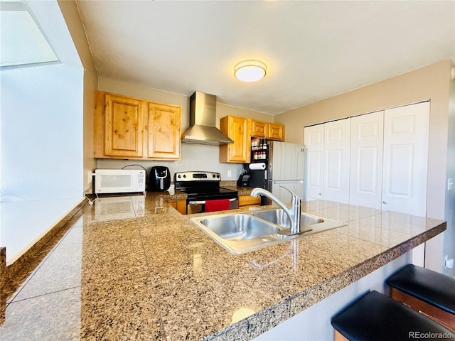 1120 S Waco St Unit A, Aurora, CO 80017 - kitchen featuring wall chimney exhaust hood, electric stove, tile countertops, freestanding refrigerator, and a sink