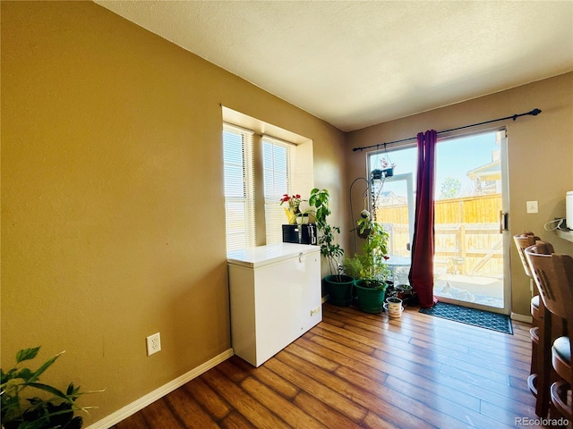 1120 S Waco St Unit A, Aurora, CO 80017 - doorway to outside with wood finished floors, healthy amount of natural light, and baseboards
