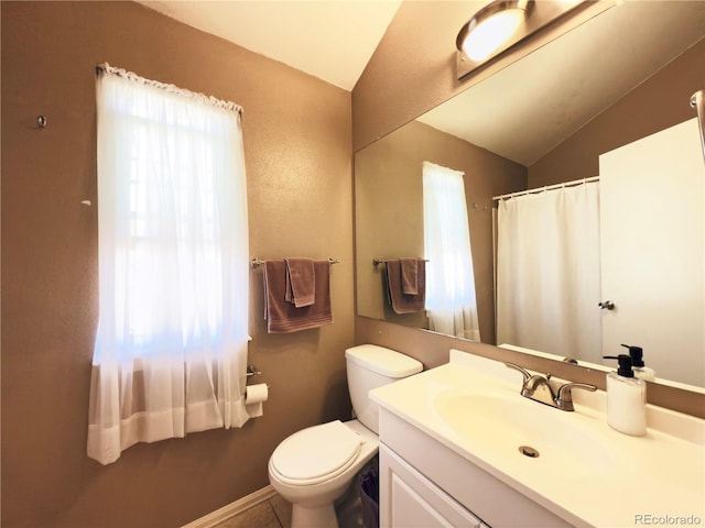 1120 S Waco St Unit A, Aurora, CO 80017 - full bath with plenty of natural light, vaulted ceiling, toilet, vanity, and baseboards