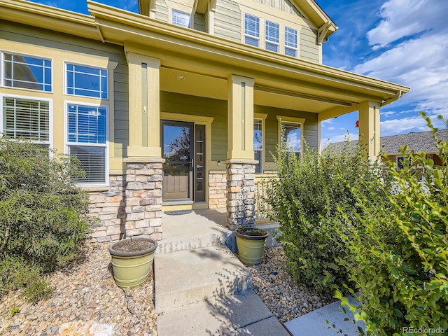 581 N Flat Rock Cir, Aurora, CO 80018 - view of exterior entry with covered porch and stone siding