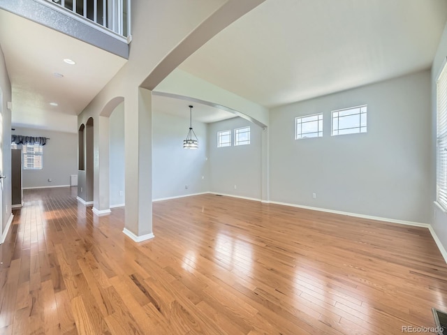 581 N Flat Rock Cir, Aurora, CO 80018 - unfurnished living room featuring light wood-type flooring and arched walkways