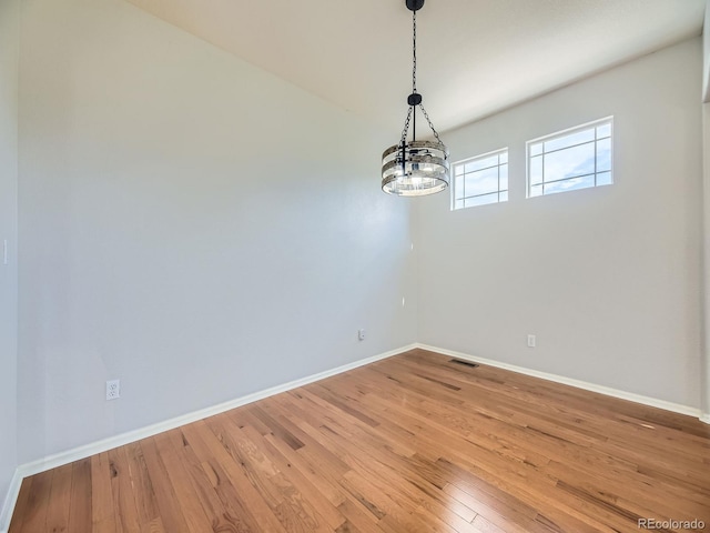 581 N Flat Rock Cir, Aurora, CO 80018 - spare room featuring a chandelier and light wood-style flooring