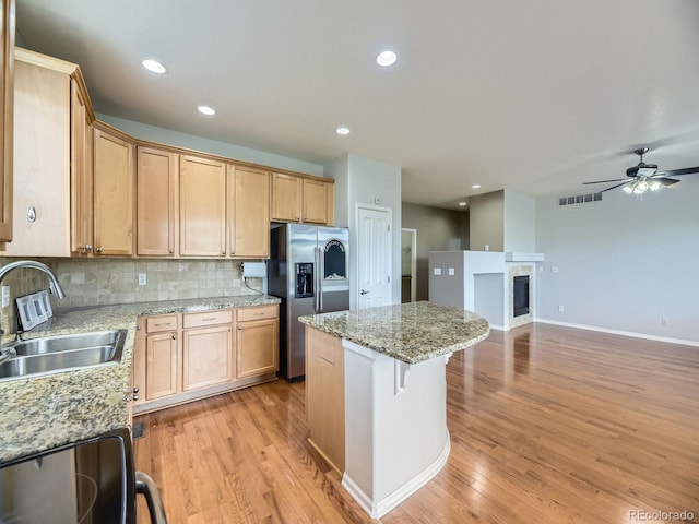 581 N Flat Rock Cir, Aurora, CO 80018 - kitchen featuring stainless steel fridge with ice dispenser, a center island, light wood-style floors, tasteful backsplash, and recessed lighting