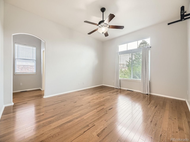 581 N Flat Rock Cir, Aurora, CO 80018 - unfurnished room featuring a ceiling fan, hardwood / wood-style floors, and arched walkways